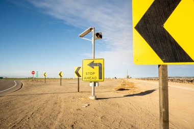 Kaliforniya, ABD 'de çöl bölgesinde yol kenarında sarı bir Dur tabelası.
