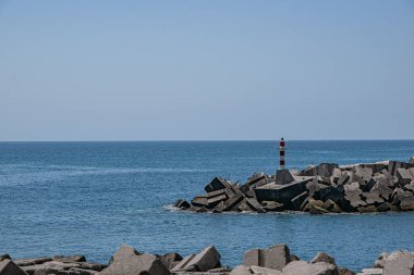 Madeira 'da okyanusun kıyısındaki kayalık bir sahilde güzel bir deniz feneri manzarası.