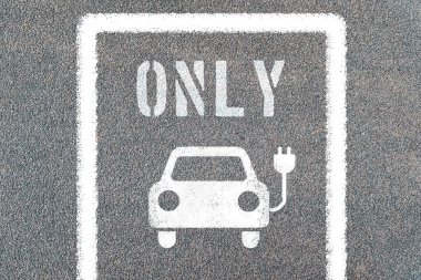Elektrikli araba sadece sembollerle park edilir. Elektrik prizli şarj istasyonu.