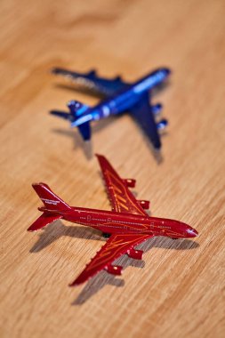 Ahşap bir masada iki oyuncak model uçak taşırken yakın plan bir fotoğraf.