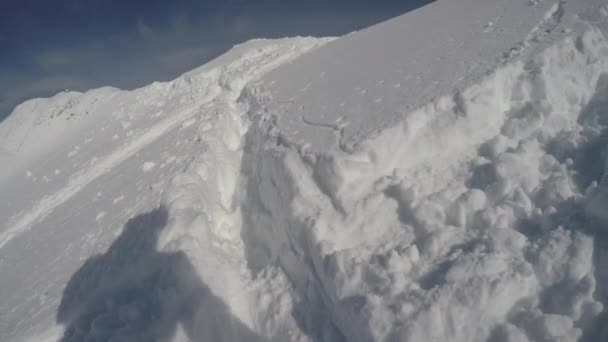 晴れた日に雪の山を歩く者 — ストック動画