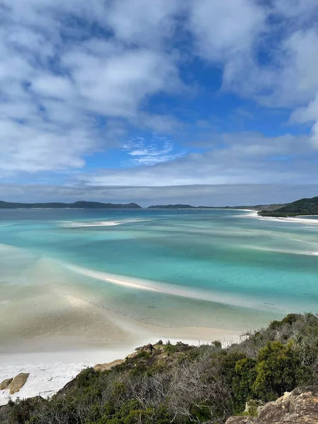 Güzel bulutlu bir gökyüzünün altında Whitehaven sahilinin manzarası.