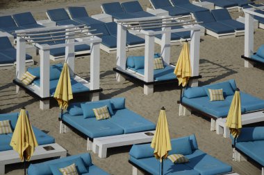 26 Mart 2022, Zandvoort, Kuzey Hollanda, Hollanda, Kuzey Denizi sahilinde mavi güneşlikler ve sarı şemsiyeler (yatay))