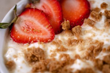 Bir kase mısır gevreği ve çilek dilimli süt.