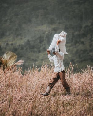 Omzunda çanta taşıyan bir işçinin dikey görüntüsü.