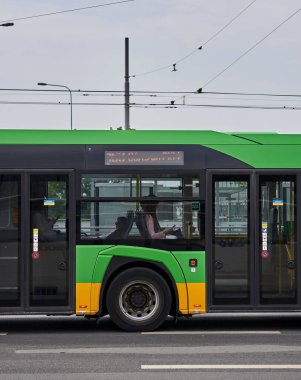 Şehir merkezinde oturan yolcuları olan bir toplu taşıma otobüsü.