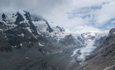Bulutlu bir arkaplanı olan karlı dağların güzel manzarası