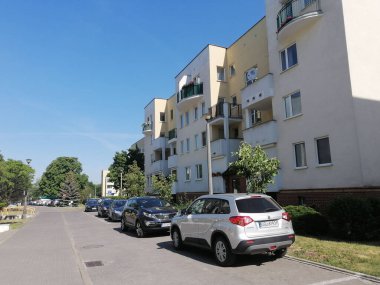 Stare Zegrze bölgesindeki apartmanların önünde bir sıra park edilmiş araba.