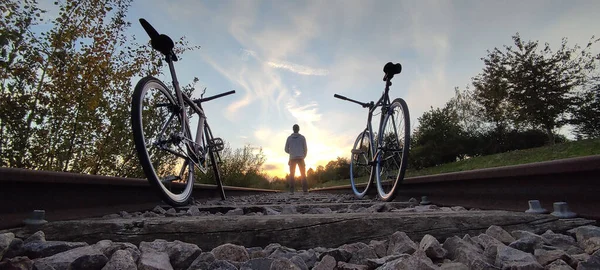 Два Велосипеда Вдоль Железной Дороги Человеком Стоящим Заднем Плане Время — стоковое фото