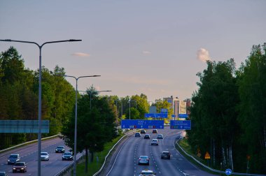 Otoyolda giden ve bahar akşamları gün batımı renkli bulutlarla gelen arabaların dinamik aralığı.