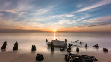 Gün batımında Cape May plajındaki kaya oluşumlarının görüntüsü