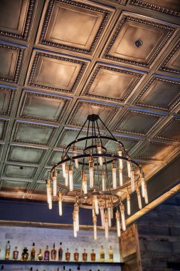 Altın tavandan sarkan antika bir avizenin dikey alçak açılı görüntüsü.