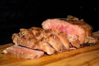 A closeup shot of slices of sirloin steak on a wooden board