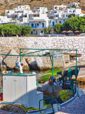 Yunanistan 'ın Sifnos adasındaki Kameras köyünde yelkenli teknesi ve binaları olan bir sahilin dikey görüntüsü