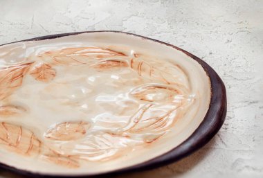 A closeup shot of an old plate with leaves pattern design