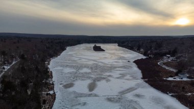 2022 kışında günbatımı Pennsylvania 'da donmuş bir göle bakıyor.