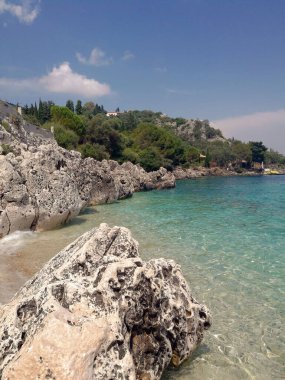 A beautiful seashore with huge rocks and trees on a sunny day