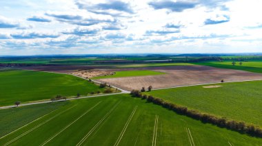 Bulutlu bir gökyüzü arkaplanı olan güzel bir yeşil arazi manzarası