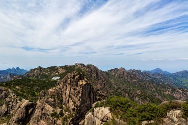 Huangshan Dağı 'nın manzarası Anhui, Çin' de mavi gökyüzüne karşı ağaçlarla kaplı.