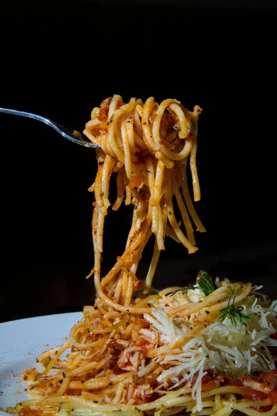 Vertical Closeup Fork Taking Spaghetti Dressed Sauce Greens Cheese White — Stockfoto