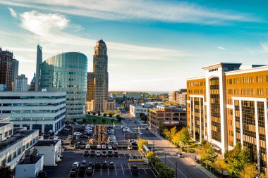 A beautiful cityscape view with modern office buildings and a parking area on a sunny day