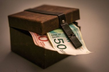 Deri sandıkta İsrail Shekel banknotlarının yakın plan çekimi.