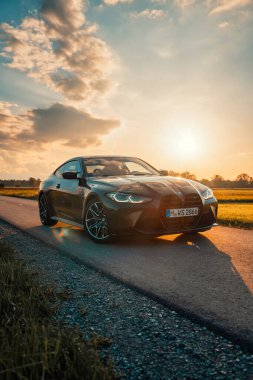 Günbatımında modern bir BMW M4 'ün, Dağ v. lüks spor arabalı görüntüsü birçok sürücünün hayalindeki arabadır.
