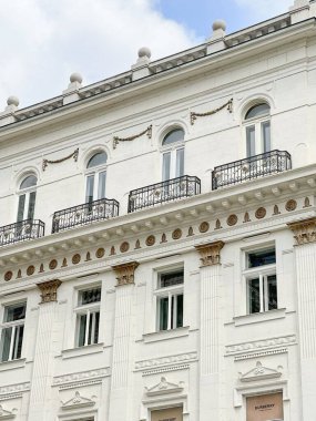 A vertical shot of a historic white building with balconies in Budapest, Hungary