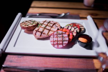 Bir tabak ızgara tavuk göğsü. Izgara patates, domates ve soğan.