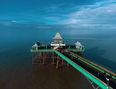 Clevedon İskelesi 'nde mavi bulutlu gökyüzünün altında yürüyen insanların güzel bir görüntüsü.