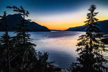 Gökyüzünde güzel bir günbatımı sırasında kırsal bir bölgedeki göl manzarası