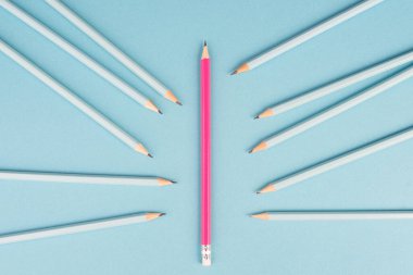 Blue pencils point to the pink one, standing out from the crowd concept, be different, leadership, mobbing issue