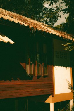 A beautiful view of an old house with fallen leaves on a roof