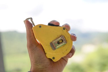 A closeup shot of a mans hand holding a measuring tools