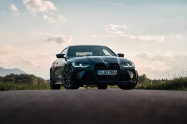 Günbatımında modern bir BMW M4 'ün, Dağ v. lüks spor arabalı görüntüsü birçok sürücünün hayalindeki arabadır.