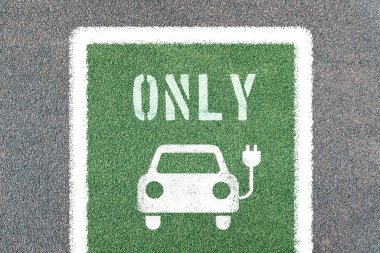 Elektrikli araba sadece sembollerle park edilir. Elektrik prizli şarj istasyonu.