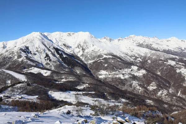 Mavi arka planda karlı dağların olduğu manzaralı bir manzara.