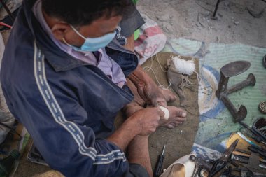 A man fixing shoes on the streets of Kathmandu, Nepal
