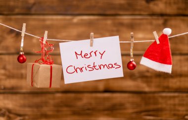 The Nicholas hat,Christmas balls, present and a note with copy space hang on a rope