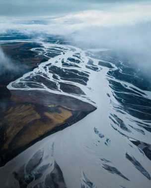 A breathtaking vertical shot of a mountain range covered with snowy on a gloomy day