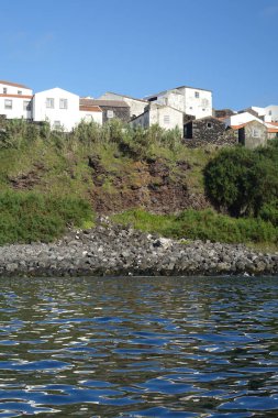 Portekiz 'in Azores şehrinde okyanustan parlak gün ışığında görülen geleneksel Corvo adası evlerinin güzel bir görüntüsü.