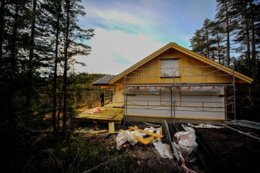 A small wooden building in construction process in a forest