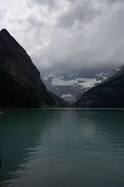 Vertical Shot Turquoise Lake Louise Surrounded High Mountains Clouds Canada — Stock Photo, Image