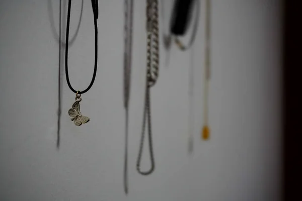 Closeup Shot Hanging Necklaces Its Shadow Wall — Stockfoto