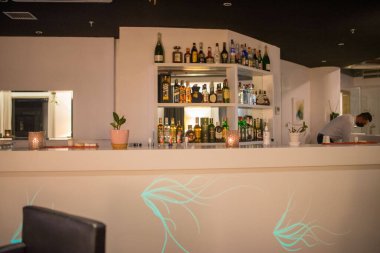 Restoran barının rafında farklı bir alkol şişesi var.