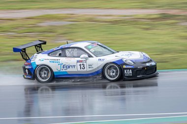 Islak pistte yarış arabası, yağmurlu bir günde. Porsche 911 Kupa 2018