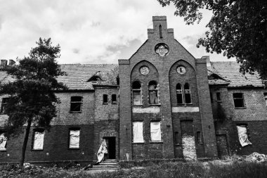 A grayscale shot of an old abandoned psychiatric building in Owinska, Poland
