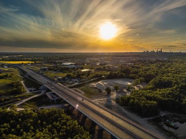 Field of rapeseed close to big city and highway. Aerial drone view
