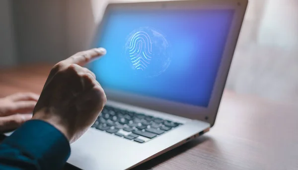 A man using a laptop with a fingerprint scanning security system