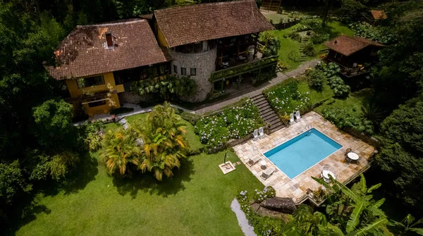 鸟瞰全景的空中 空旷茂盛的热带花园绿地 游泳池在山边 外立面是风景如画的石头酒店 — 图库照片